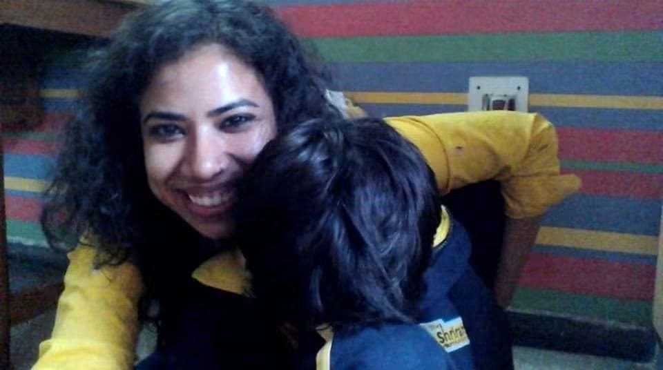 Prachi being hugged by a young client, the child’s face hidden in her shoulder