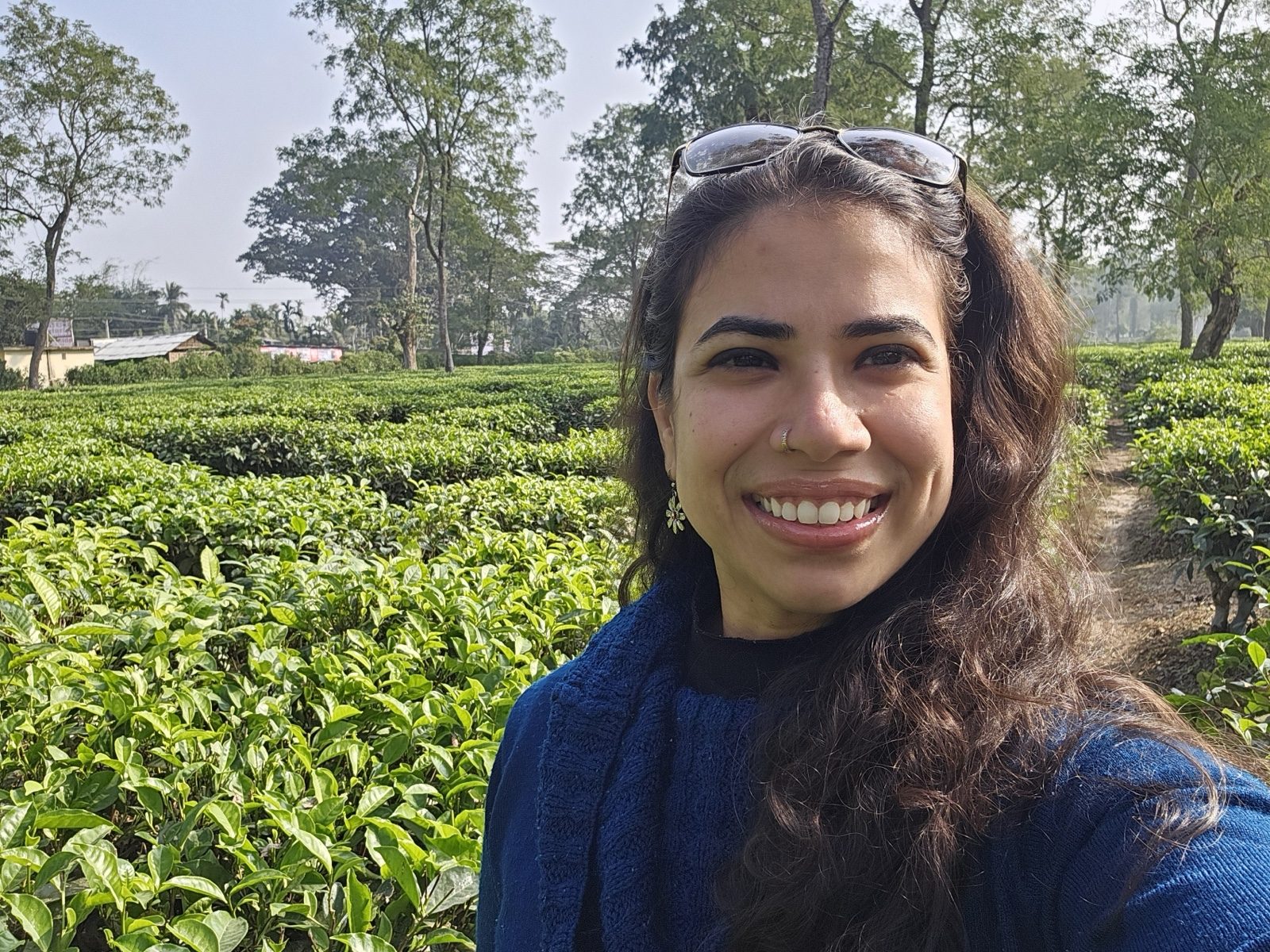 Prachi Srivastava in a tea garden, smiling at the camera