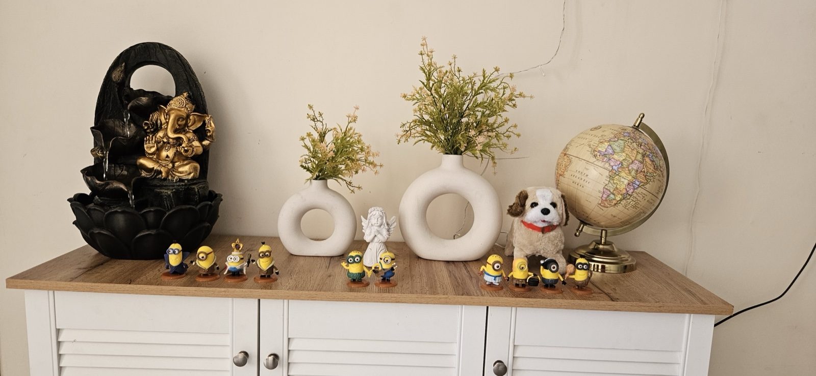 A warm shelf in Prachi&rsquo;s therapy room with figurines, plants, and a globe