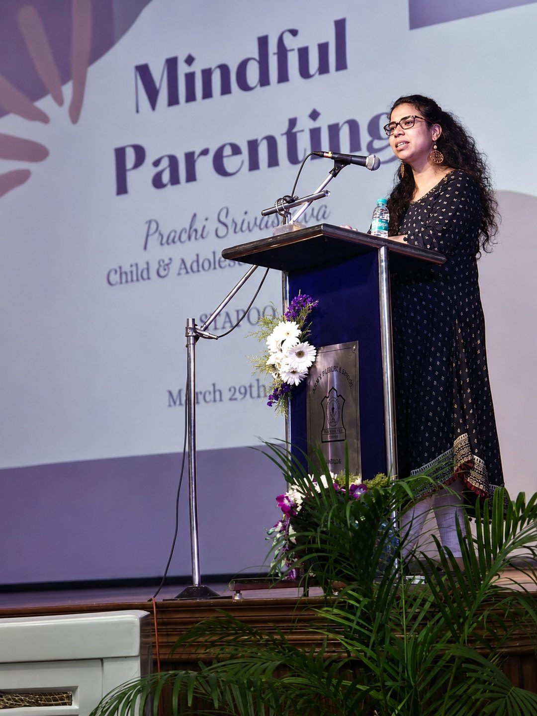 Prachi Srivastava speaking at a podium during a Mindful Parenting workshop, in front of a Stapoo-branded backdrop